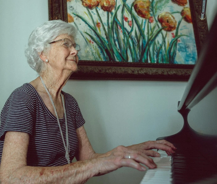 a woman in striped shirt playing a piano