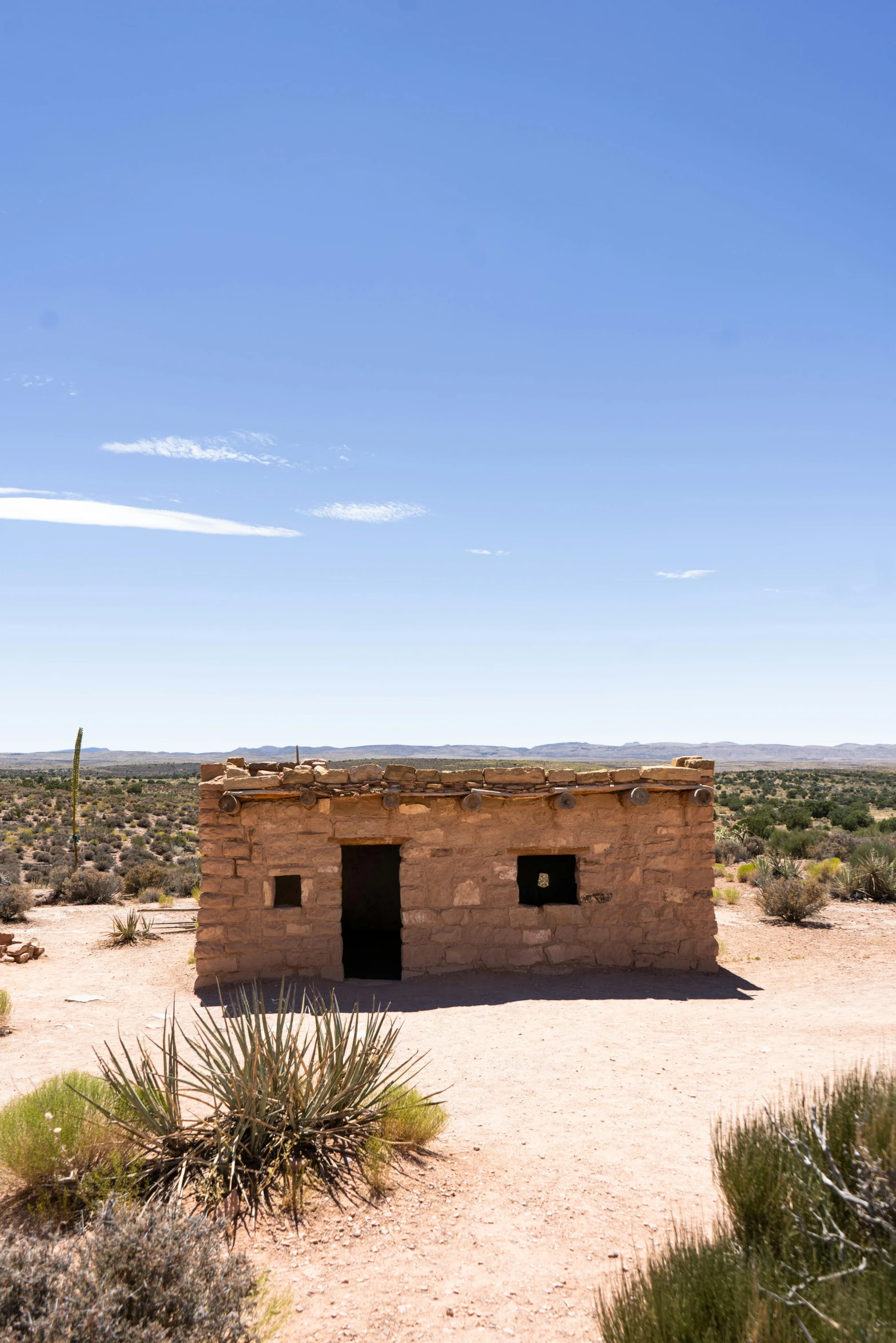 an outhouse in the desert on a sunny day