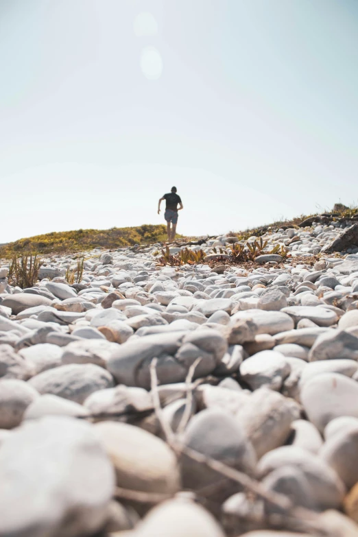 man standing on top of a rocky hill next to a forest