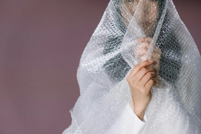 the veil is covering a woman's head from rain