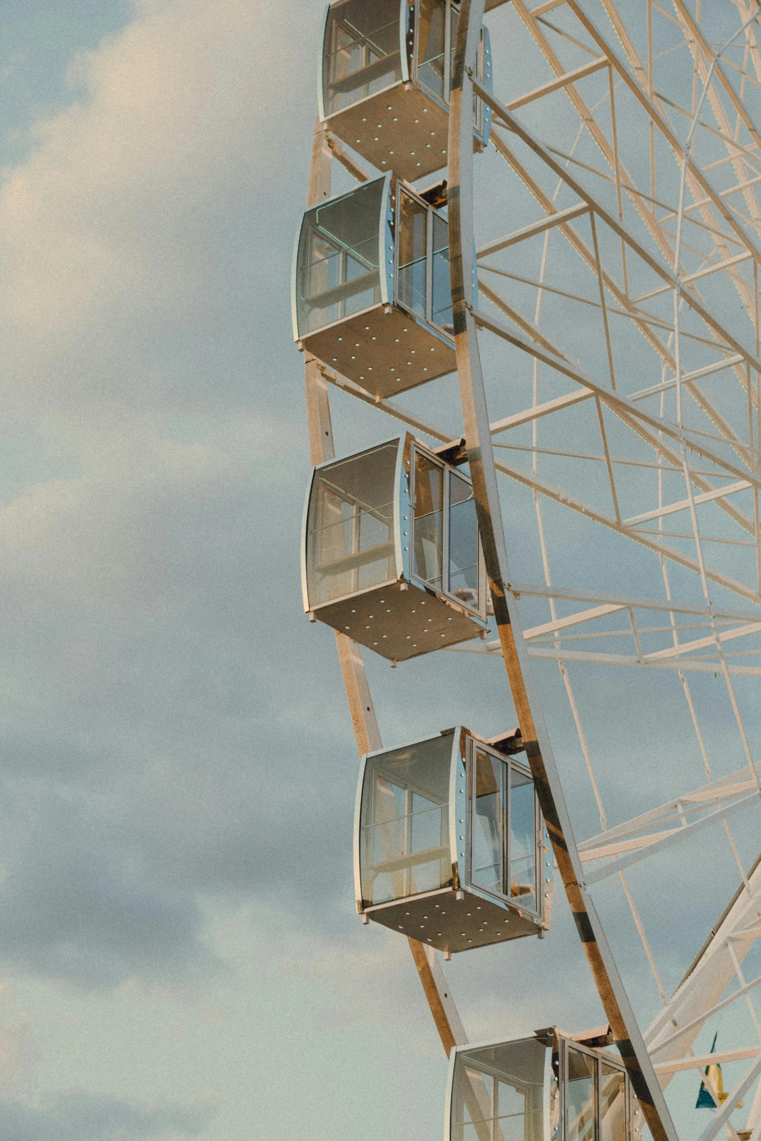 the ferris wheel is in motion against a cloudy sky