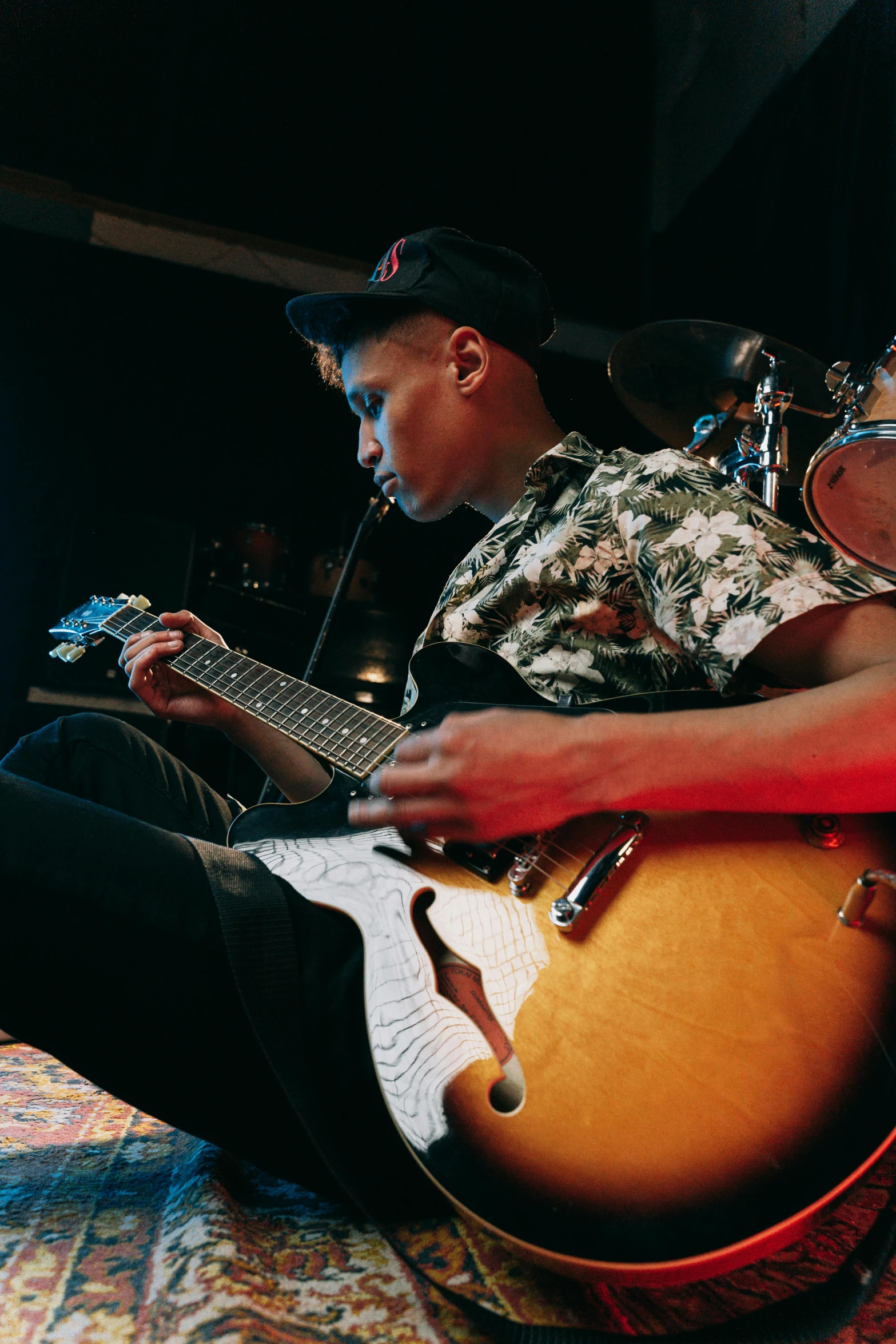 a man is sitting down playing a guitar