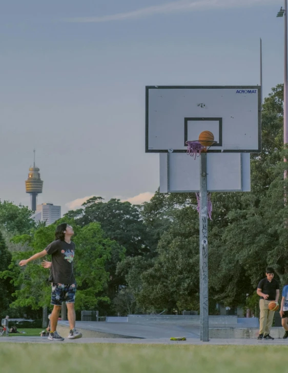 two people are playing basketball with the sky in the background