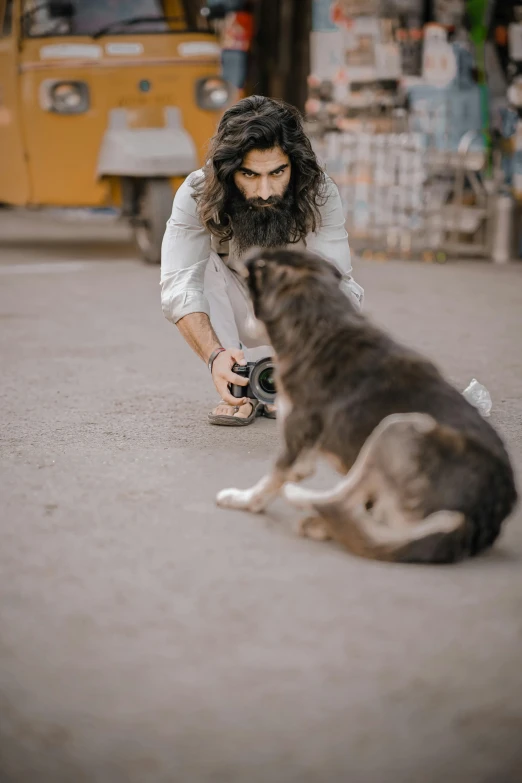 the man is taking pictures of the dog and a person with a camera