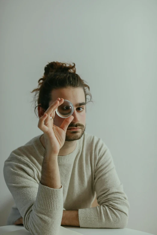 a man with long hair holding an object up to his face