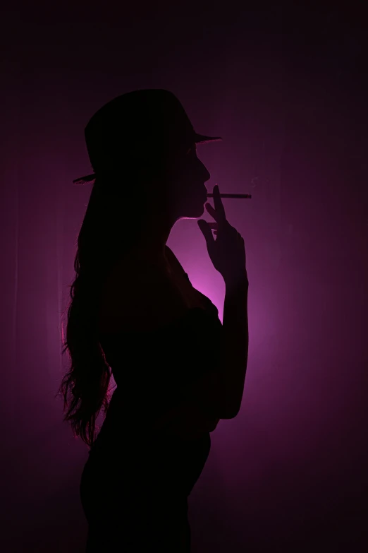 a silhouette of a woman smoking and looking at the camera