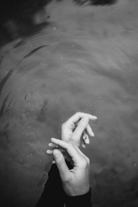 two hands pointing towards each other in the water