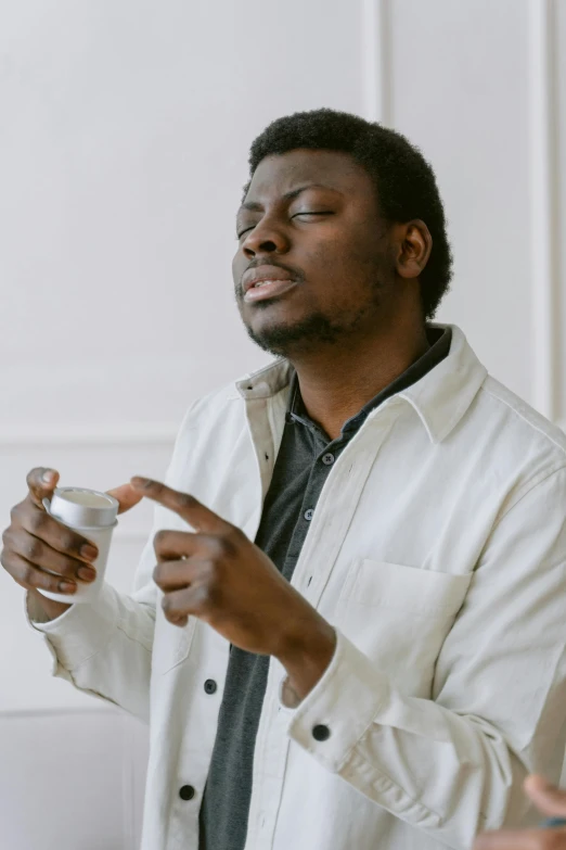 a man is holding a cup of coffee