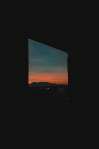 the view of the sky and mountain behind a small window