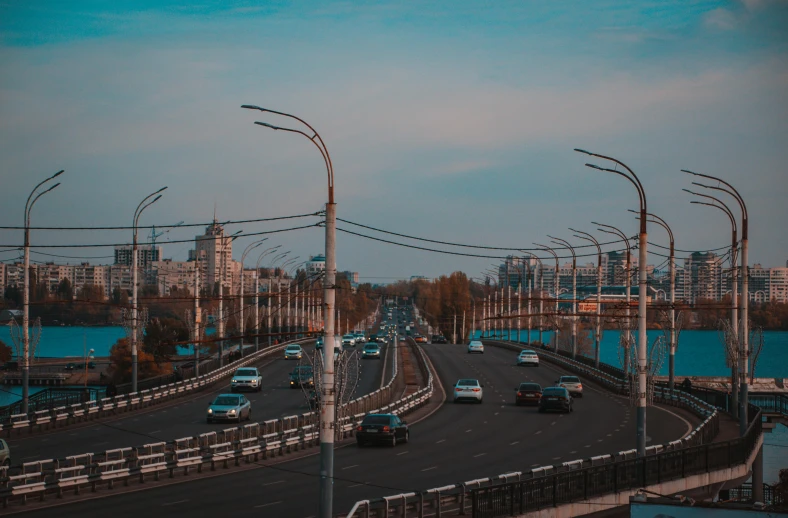 a road with several cars driving down it and a tall building with many windows