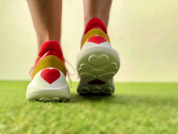 a person with heart shaped sneakers on walking in grass