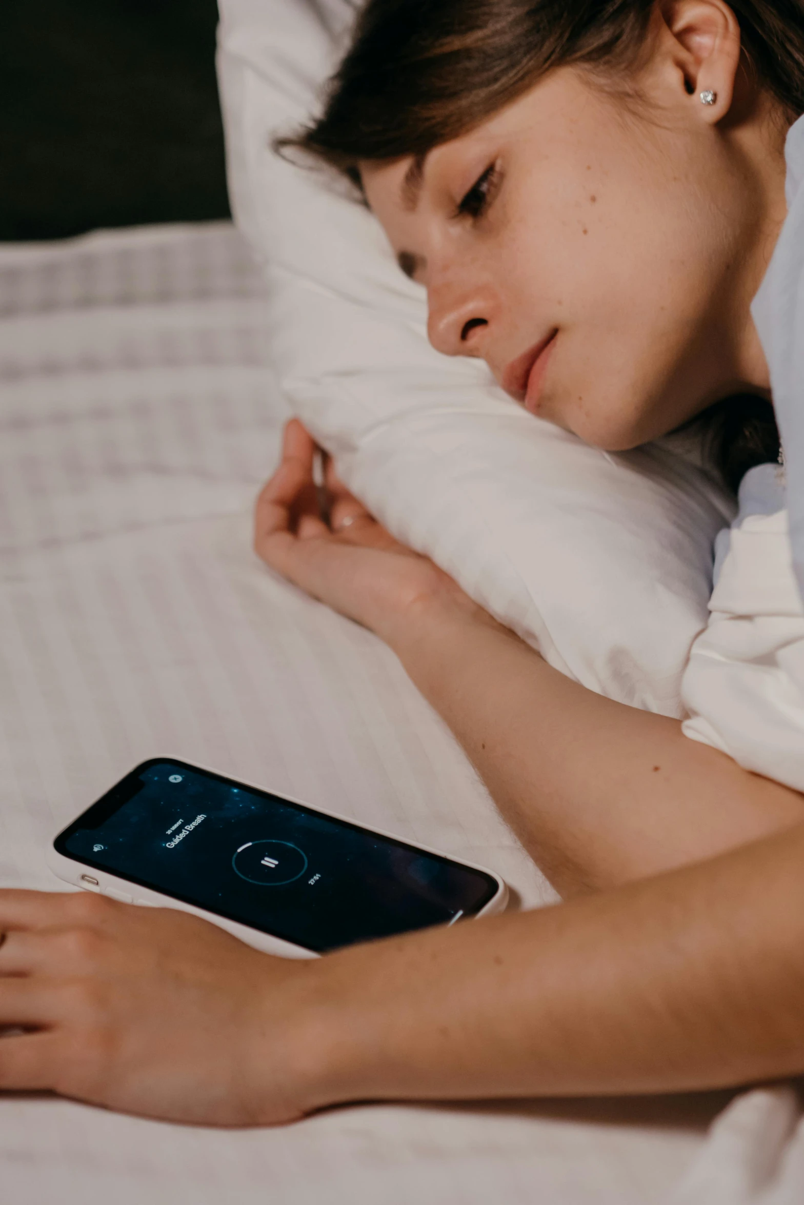 a woman sleeping on her bed with a phone