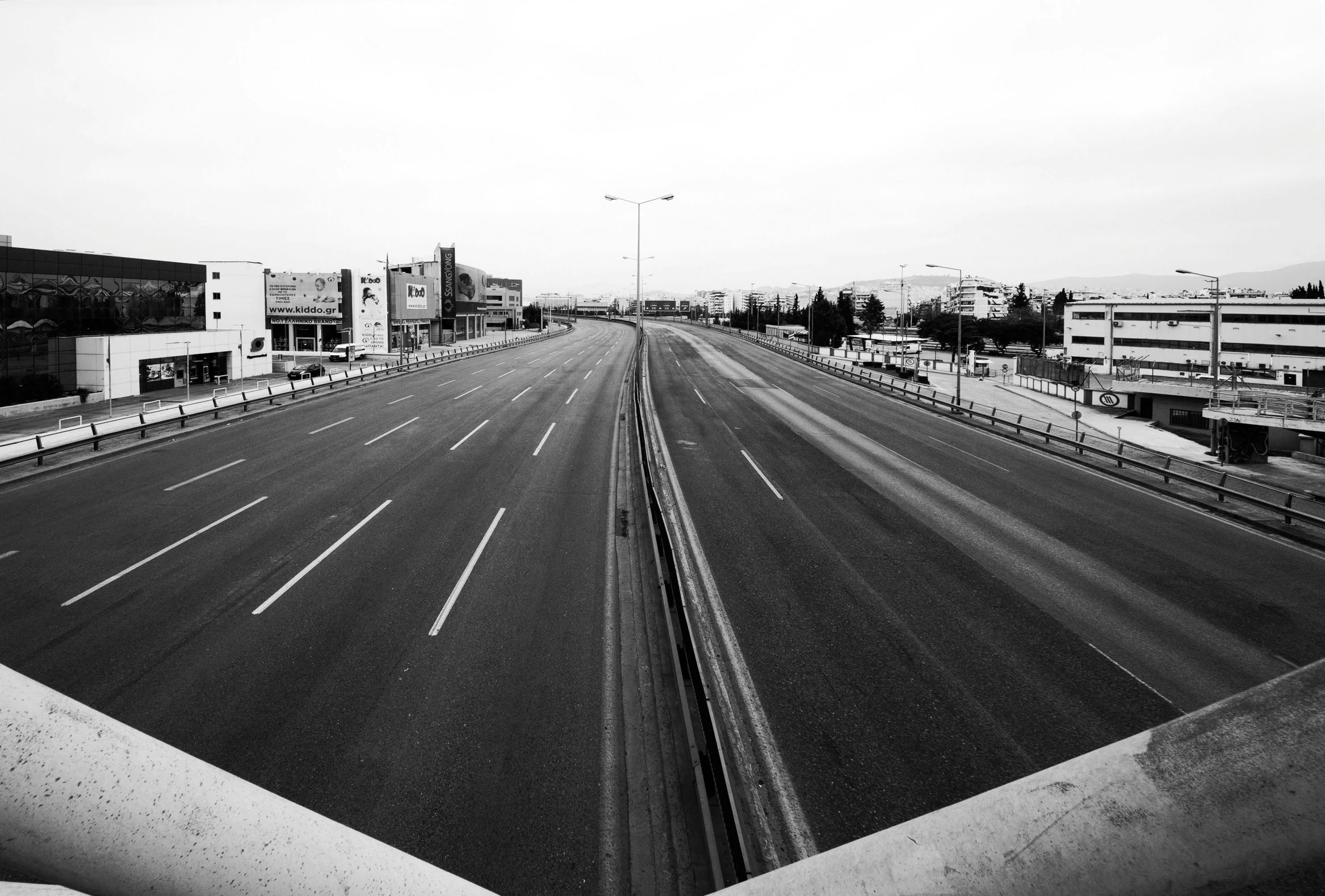 black and white image of an empty street with buildings