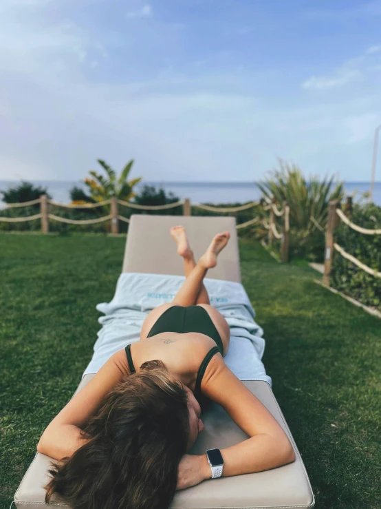 a woman laying down on a mat in the grass