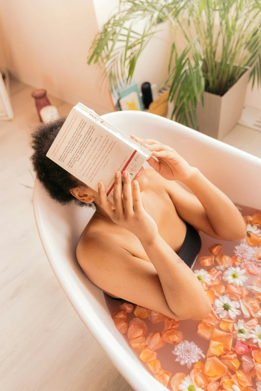 a women reading a book while laying in an inner tub