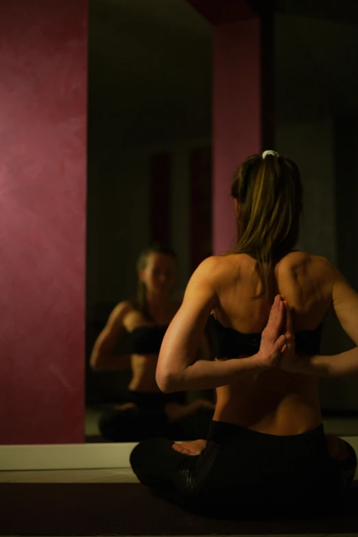 this is a woman doing yoga in front of some mirrors