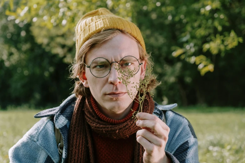 a person standing in a field holding a piece of grass