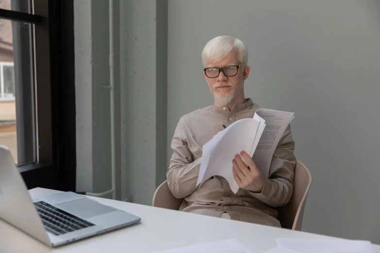 a man sitting at his computer reading paper