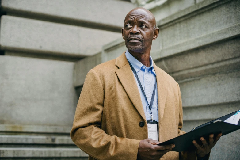 a man holding a book looking off into the distance