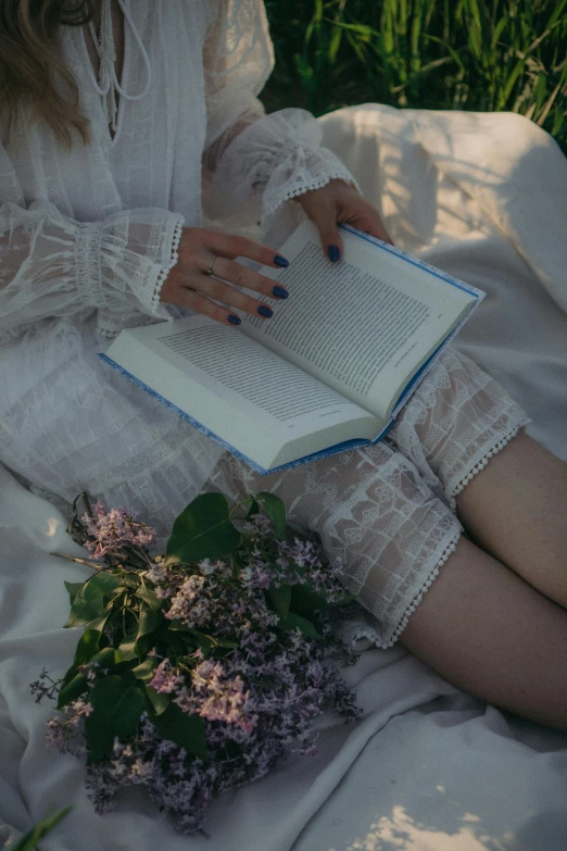 a woman laying down with a book in her lap