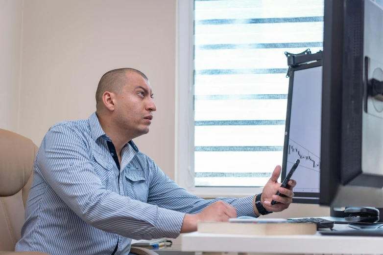 a man that is sitting in front of a screen