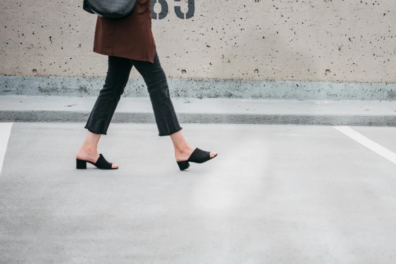 woman in heels walking away from a wall