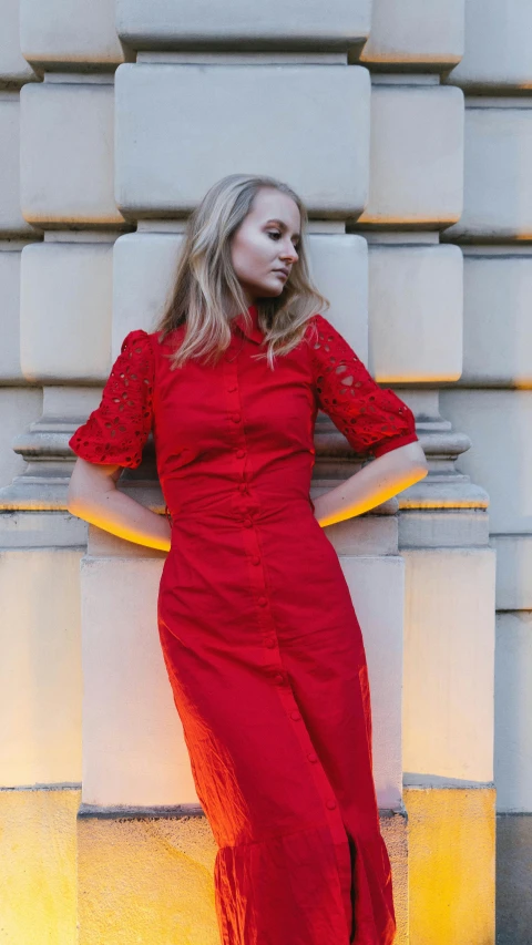 a woman is standing against a wall posing for the camera