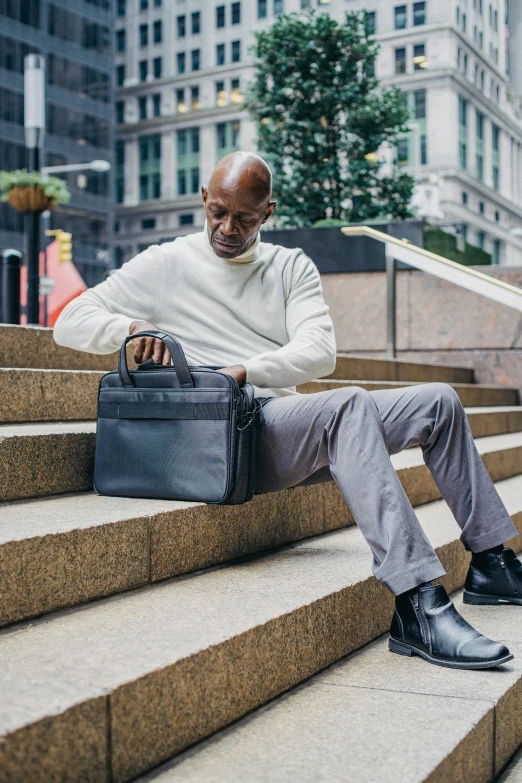 a man sitting on the steps with his suit case