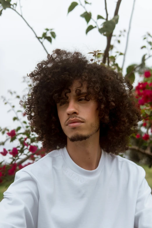 the man is sitting down and wearing a big afro