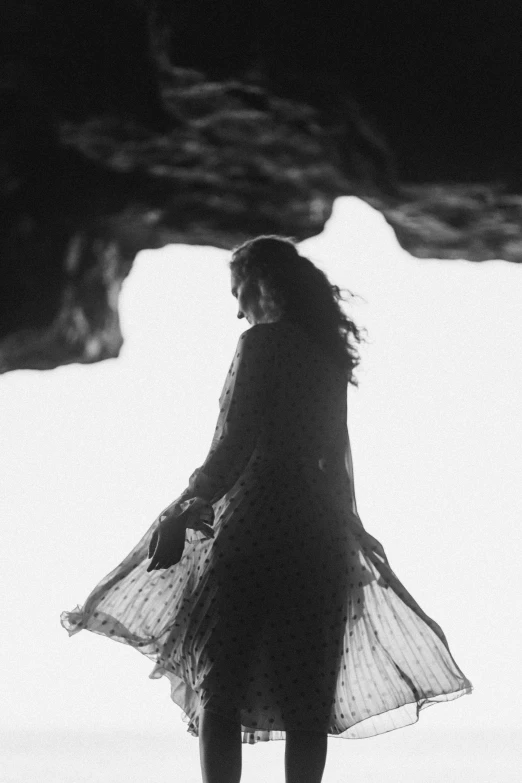 a person with a long dress walking across snow