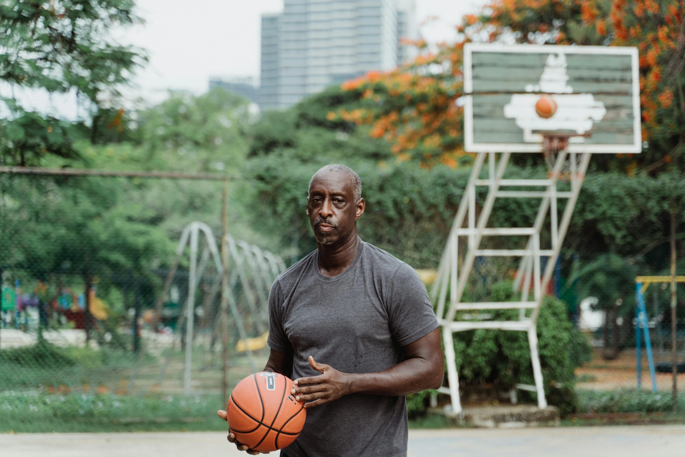 a man holds a basketball in front of a basketball court