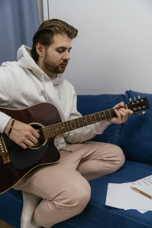 a man playing guitar on a couch