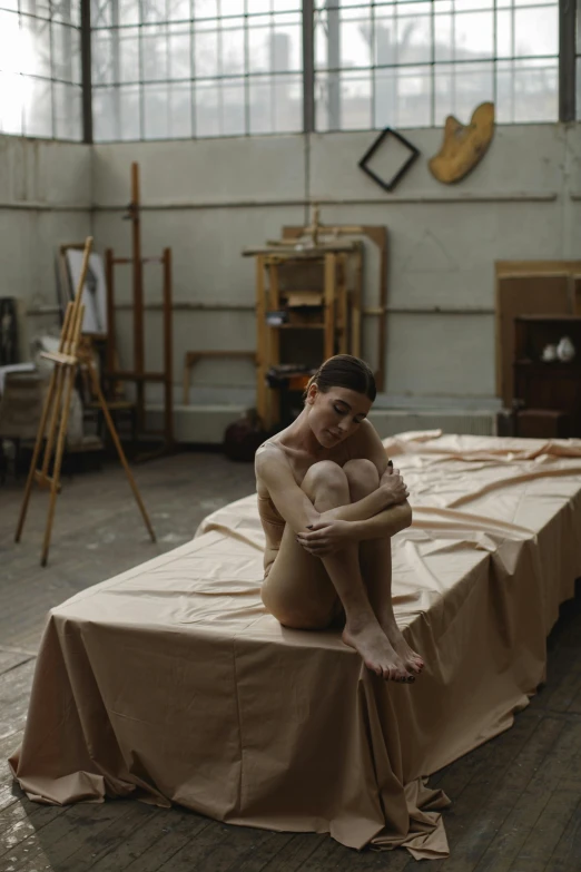 a woman posing  on top of a mattress