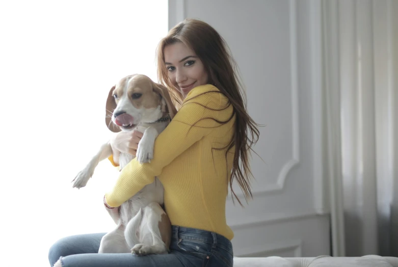 a young lady holds her dog in her arms