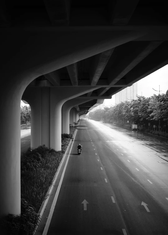 a motorcycle on the side of an open road under a highway