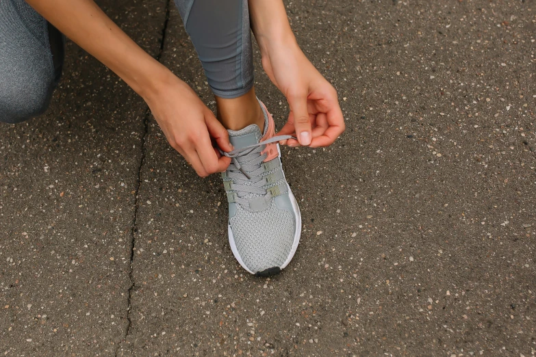 a person putting soing in their shoelaces for running