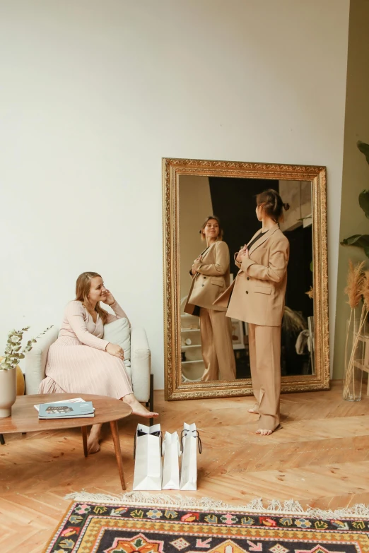 the image is taken in the mirror as two women look at their own reflection