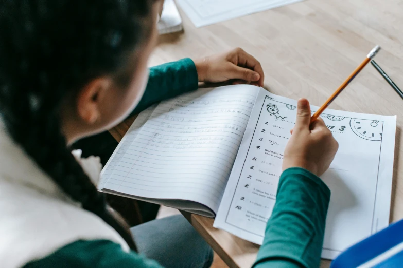 a person who is sitting at a desk with some papers and pencil