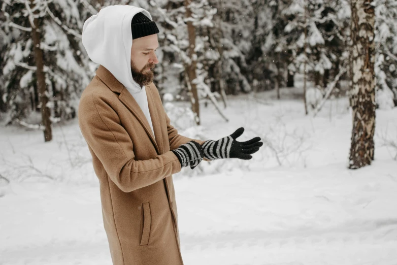 a man standing in the snow in a coat