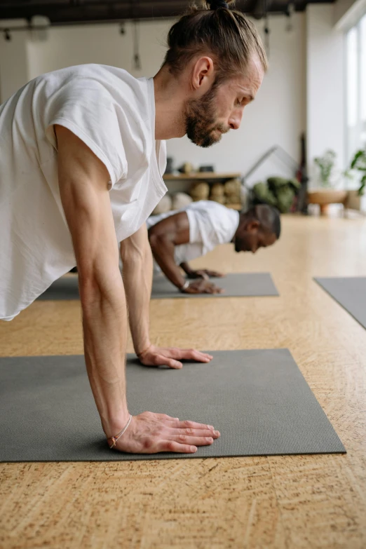 a person doing a downward hand - to - floor pose in a studio