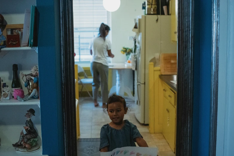 a boy is sitting at a table in a kitchen