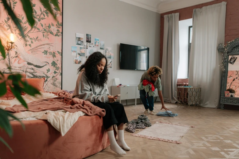 two girls in a room with floral wall paper