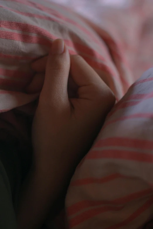 an extreme closeup of someone's hand under a blanket