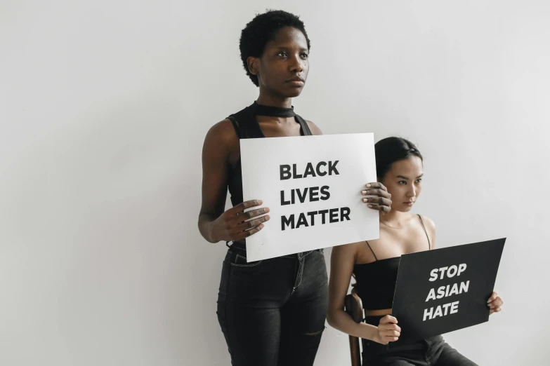 two women hold up signs with words and sayings