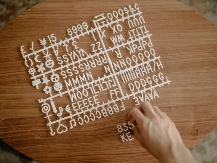 someone making numbers and symbols on a wood table