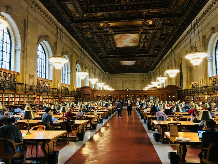 a long room filled with people next to tables