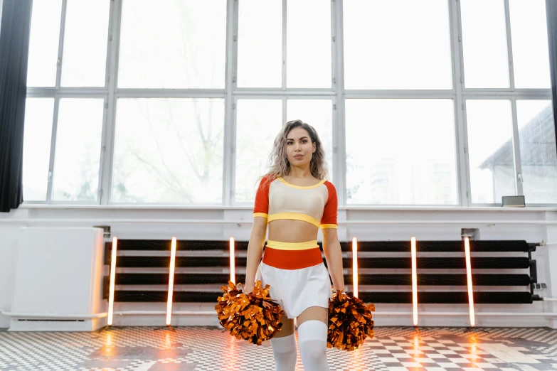 a woman with two hands on her hip and some cheerleaders