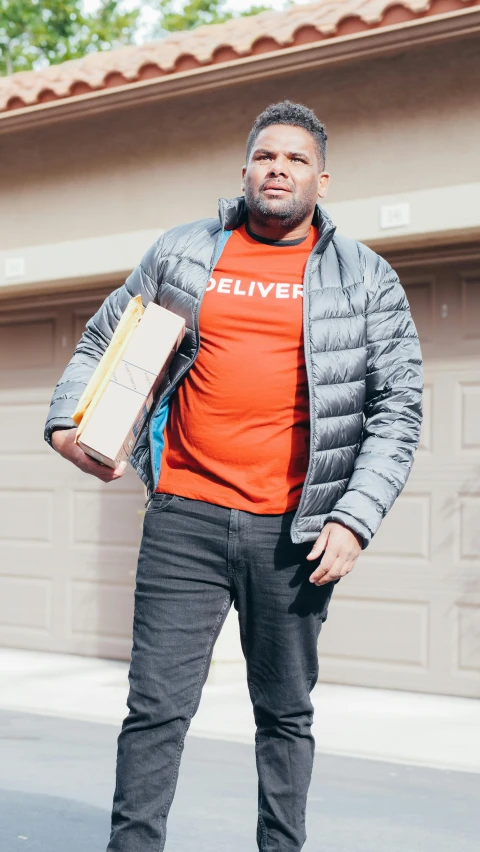 a man in an orange shirt is standing with a backpack