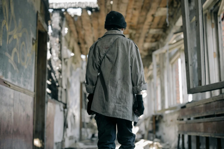 a man walking away from the camera in an old building