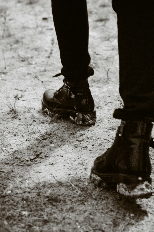 two people's shoes on top of a rocky surface